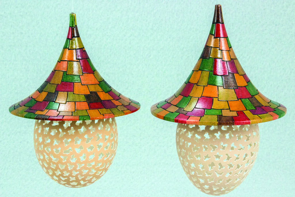 Decorative lamps with colourful shingle-like roofs.
