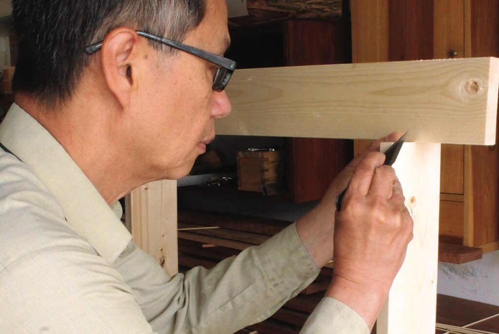 Man woodworking, cutting joint in workshop