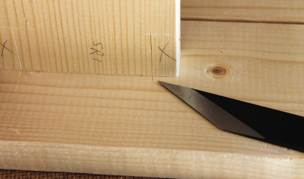 Chisel and marked wood for joinery precision.