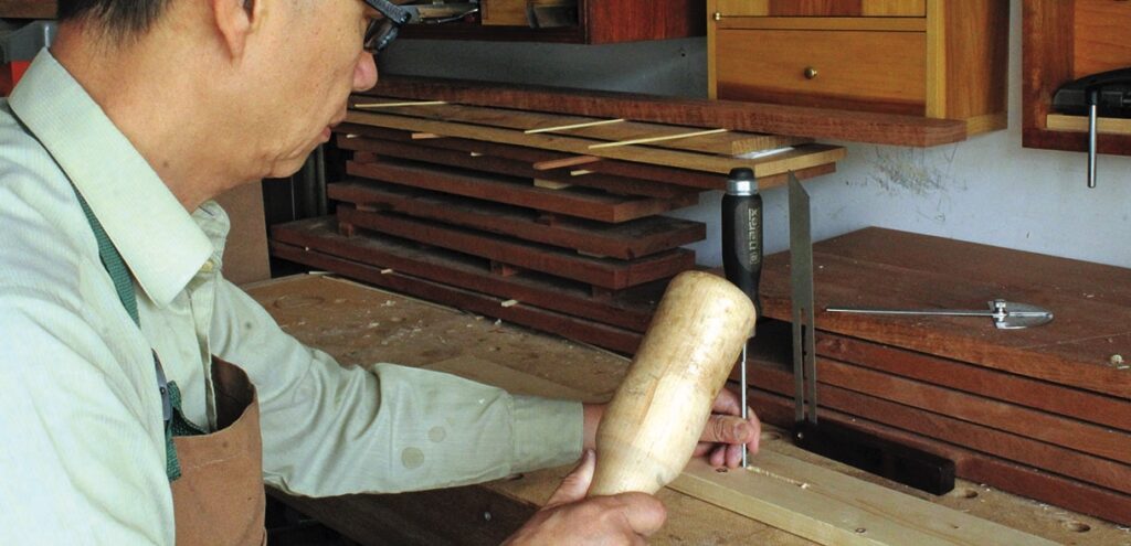 Carpenter chiseling wood in a workshop