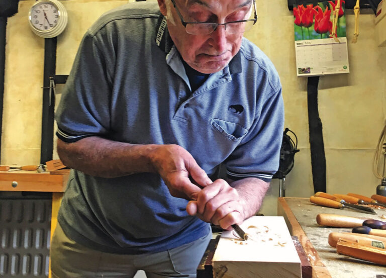 Man carving wood in workshop