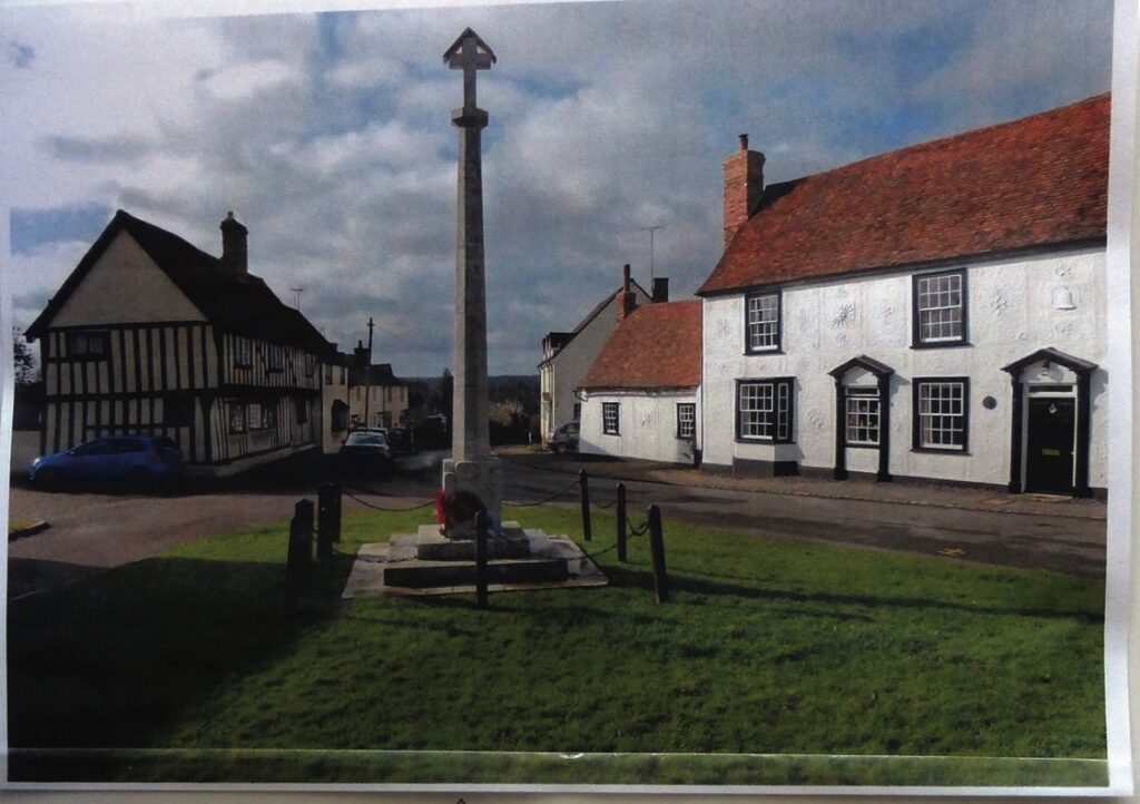 Historic village crossroads with war memorial and houses.