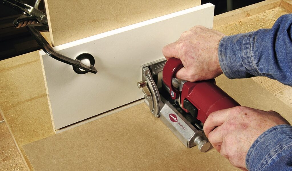 Cutting wood with a biscuit joiner tool.