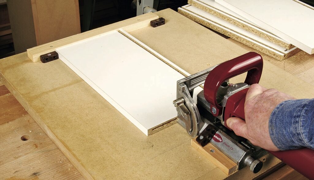 Person using a biscuit joiner on wood.