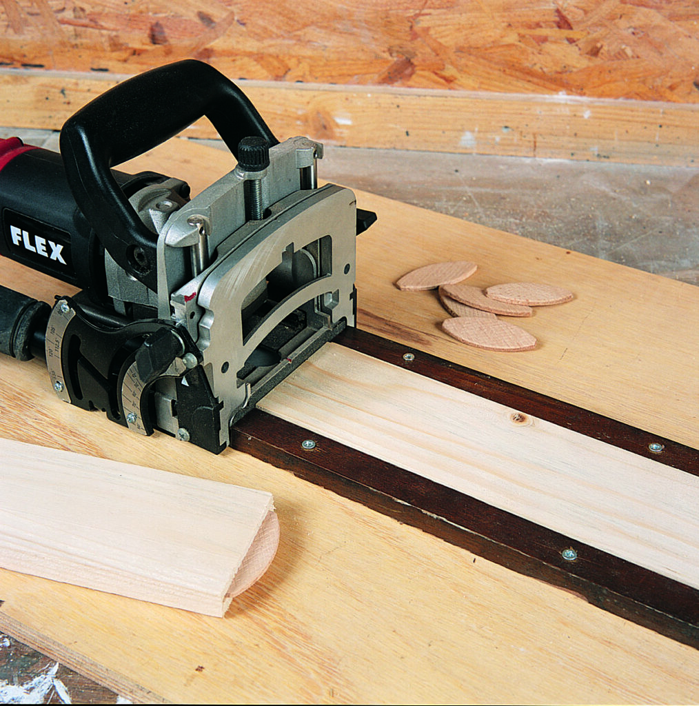Biscuit joiner and wood biscuits on workbench.