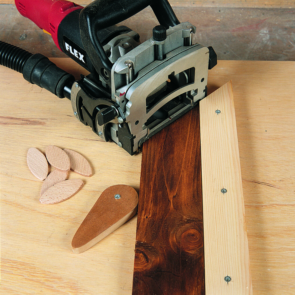 Biscuit joiner with wooden biscuits on workbench.