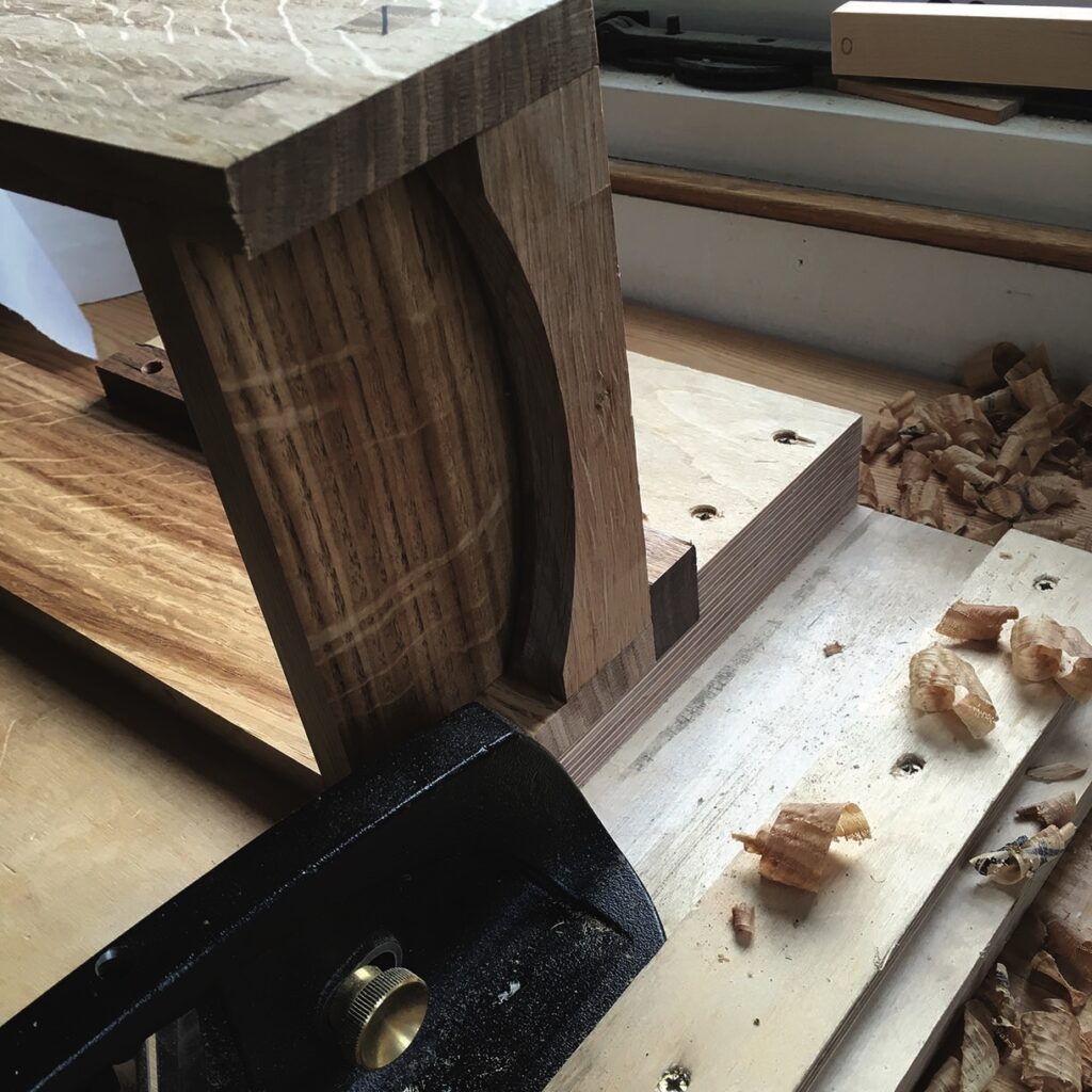 Woodwork project with plane and shavings on table.