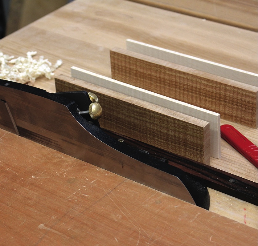 Woodworking saw and wooden boards on workbench.