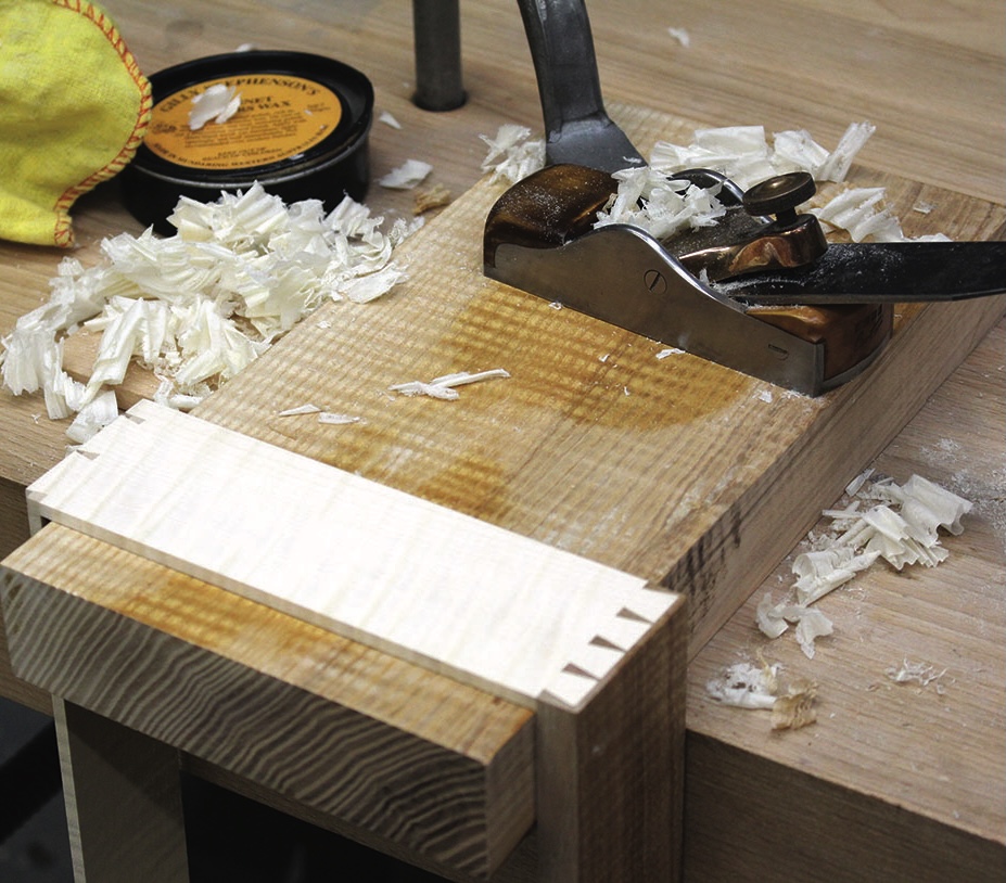 Woodworking with hand plane and wood shavings.