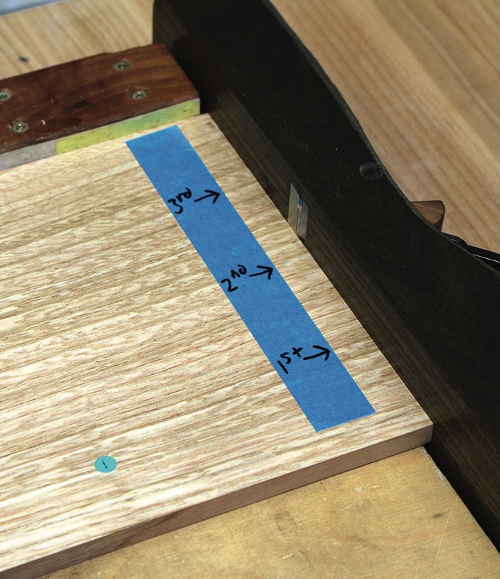 Wood board with blue tape and numbered markings.