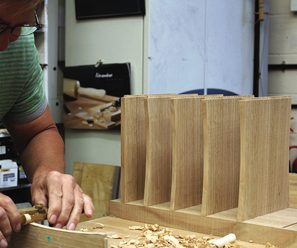 Woodworker crafting a wooden bookshelf carefully.