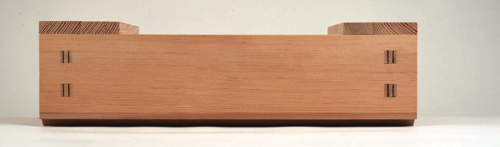 Wooden box with interlocking joints on shelf.