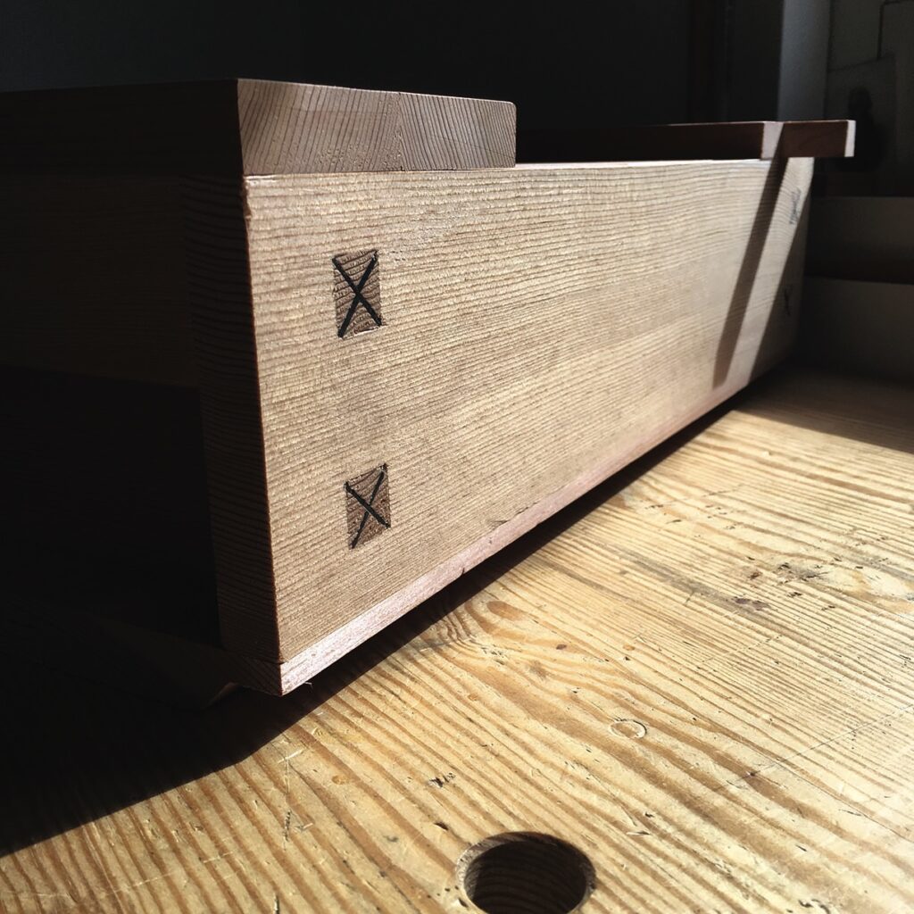 Wooden dovetail joint in warm sunlight.