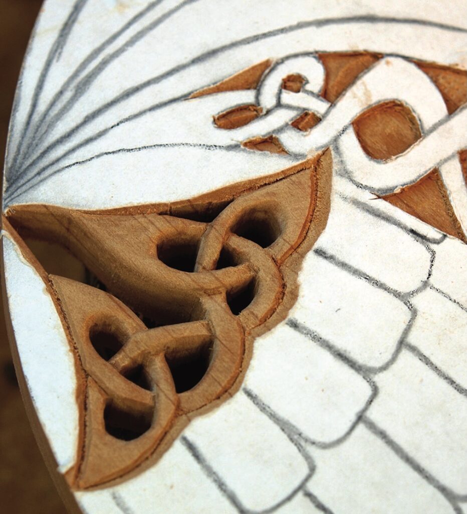 Intricate wood carving in progress, Celtic knot design.