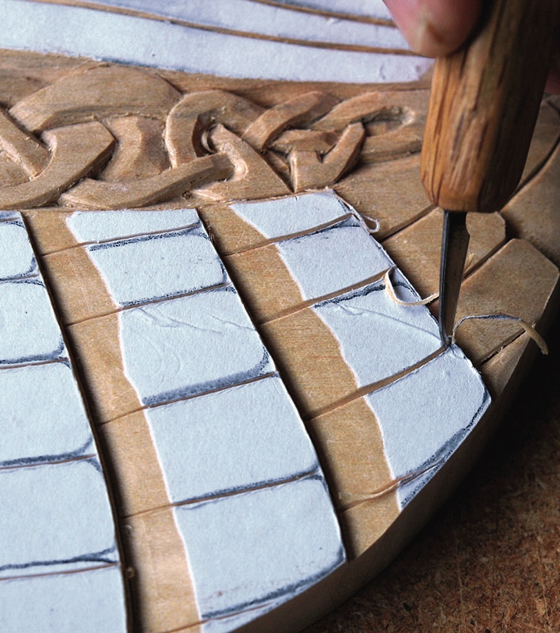Wood carving process with intricate design details.