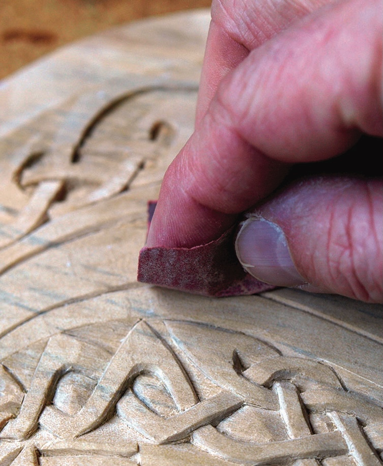 Hand sanding carved wood details carefully