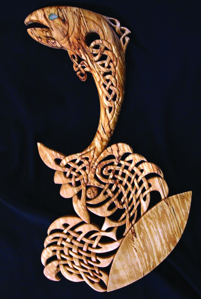 Intricate wooden carving of Celtic-style leaping fish