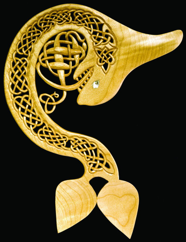 Intricate wooden carved dolphin with Celtic designs.