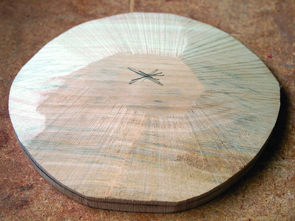Round wooden lute soundboard with rosette design.