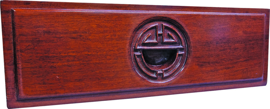 Wooden drawer with circular carved design detail.