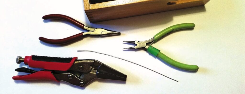 Jewellery pliers and wire on table.