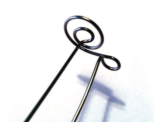 Metal spiral hairpin on white background.