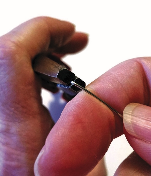 Person bending wire with pliers.