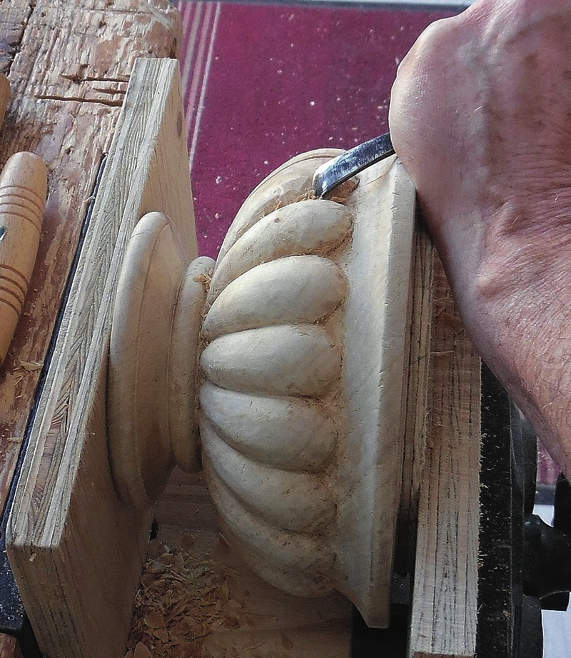 Hand carving detailed wooden ornament with chisel