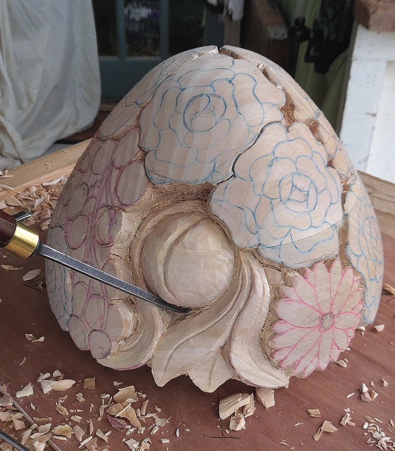 Intricate wooden carving with floral designs, partially carved.