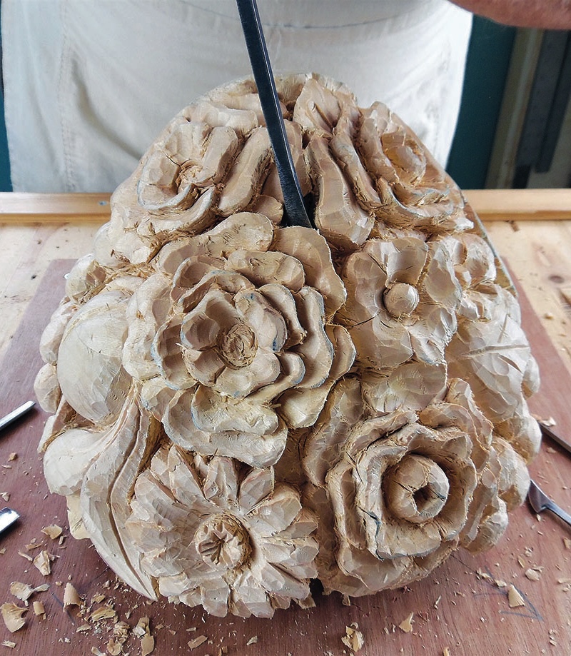 Wooden sculpture with floral carvings in progress.