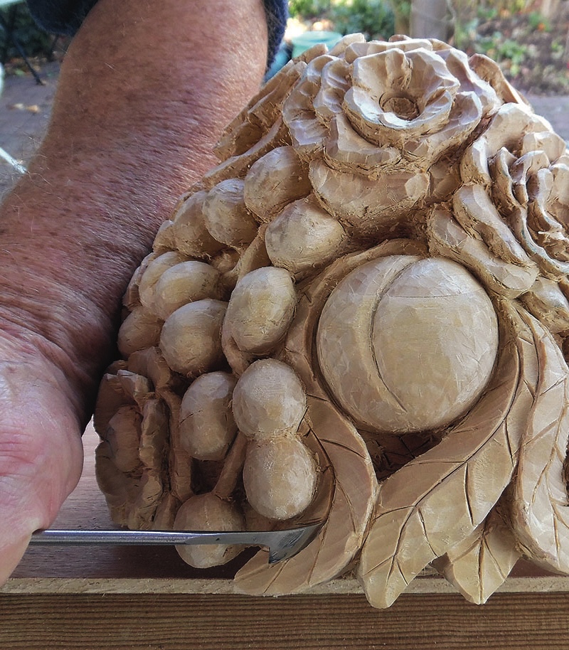 Detailed fruit carving with chisel in progress
