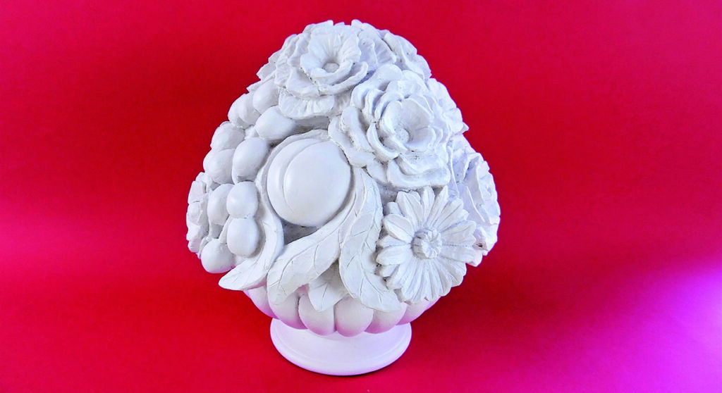 White floral sculpture on bright pink background.