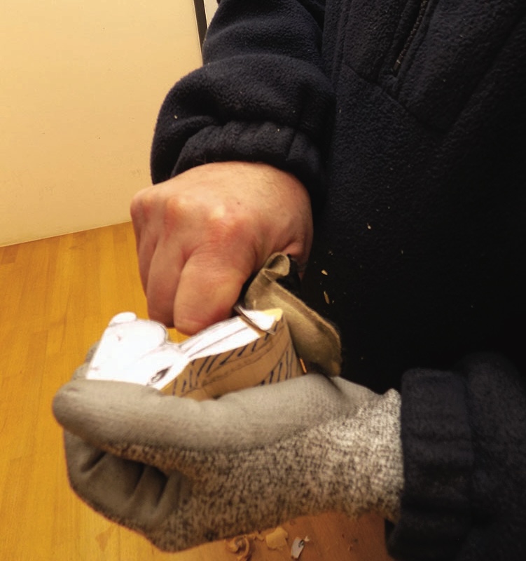 Person carving wood with a knife.