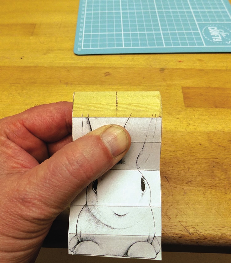 Hand holding flipbook with a rabbit drawing.
