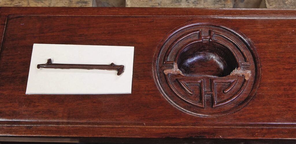Wooden table with carved circular design and stick.