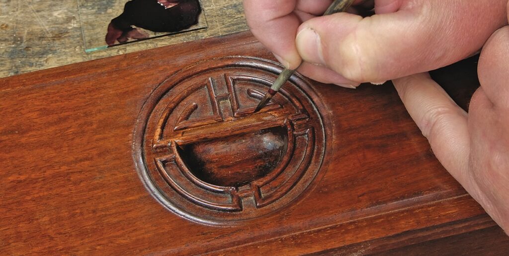 Engraving wood with precision tool in workshop.