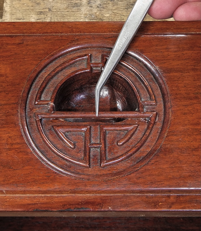 Carved circular pattern with metal tool insertion.