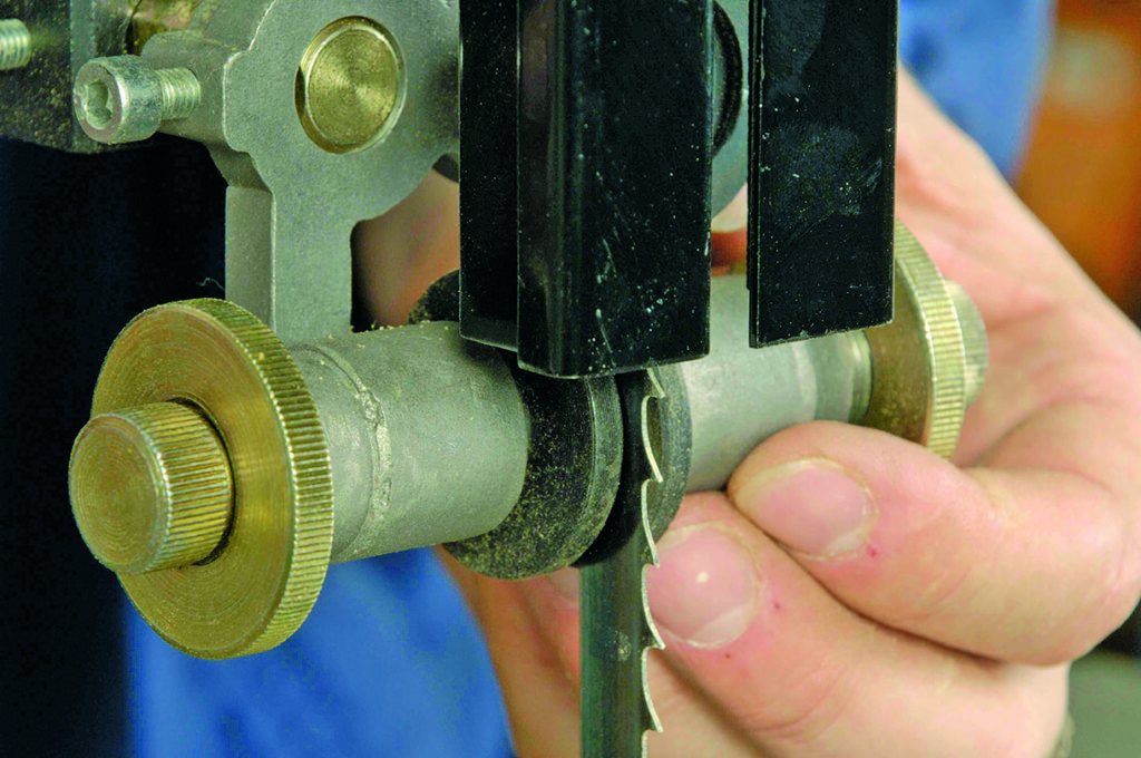 Adjusting a bandsaw blade guide mechanism.