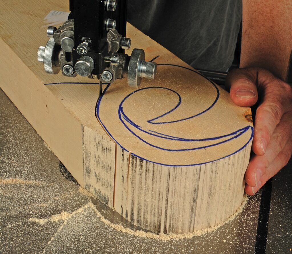 Bandsaw cutting wood with marked pattern.