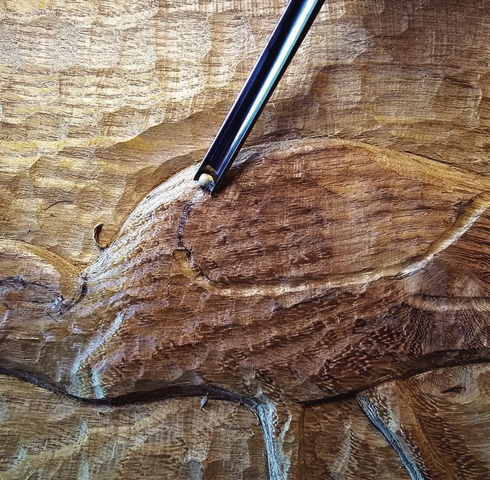 Carving tool etches intricate design in wood