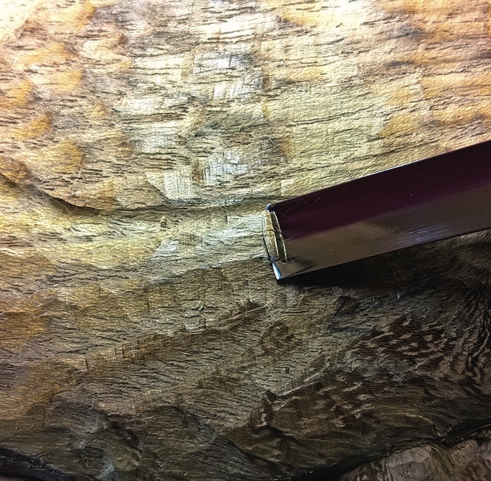 Wood carving tool with textured wooden background