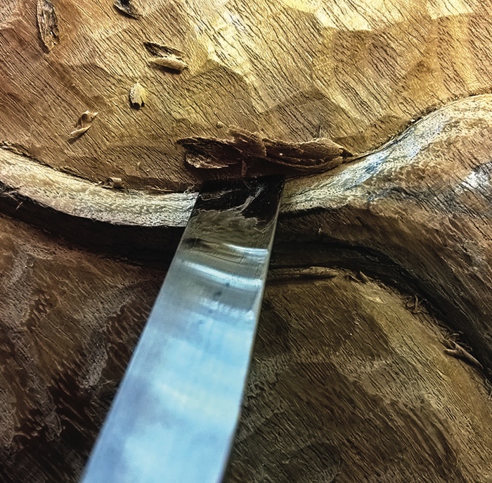 Close-up of woodcarving with chisel tool.