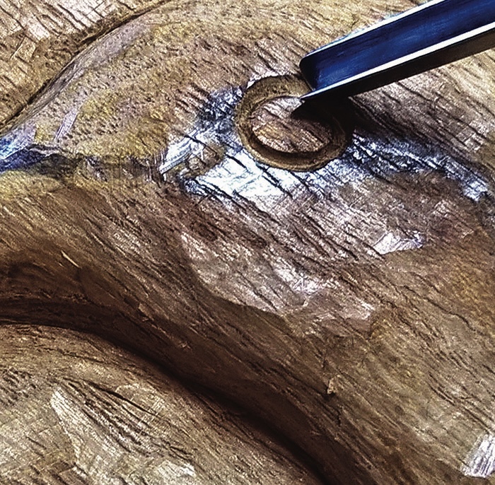 Wood carving with chisel in close detail.