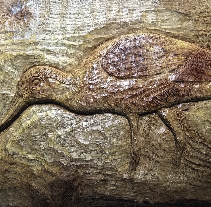Wooden carving of a long-beaked bird.
