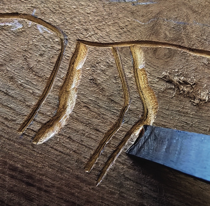 Close-up of wood carving with chisel.