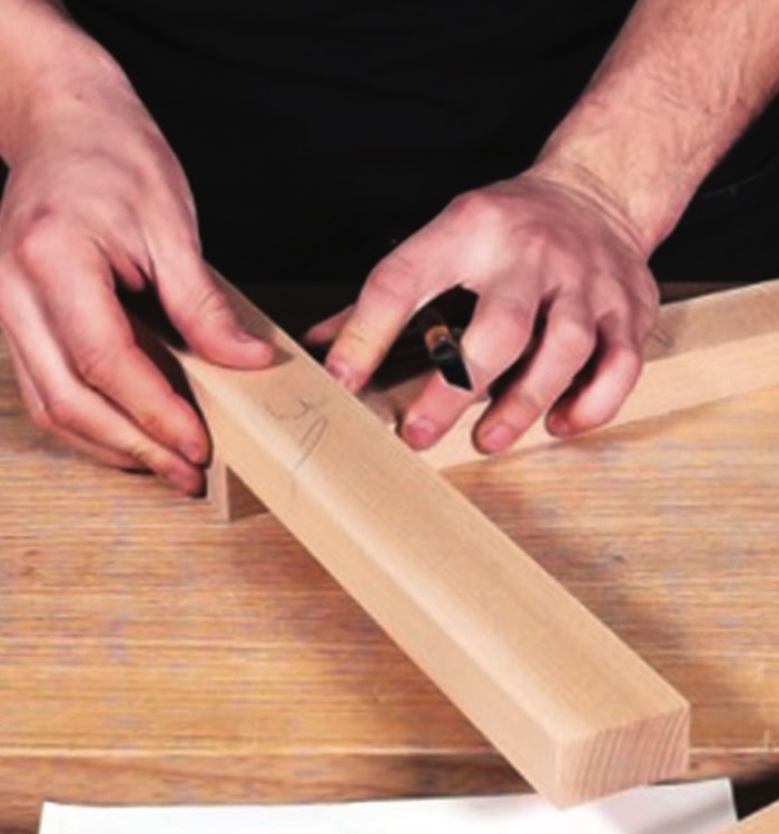 Carpenter measuring wooden beam for precision cutting.