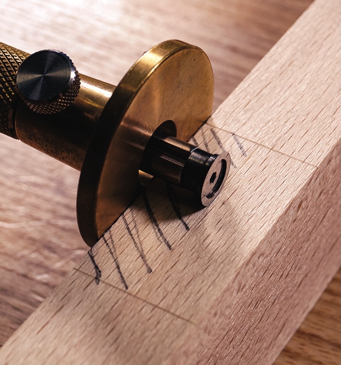 Woodworking depth gauge on marked wooden surface.