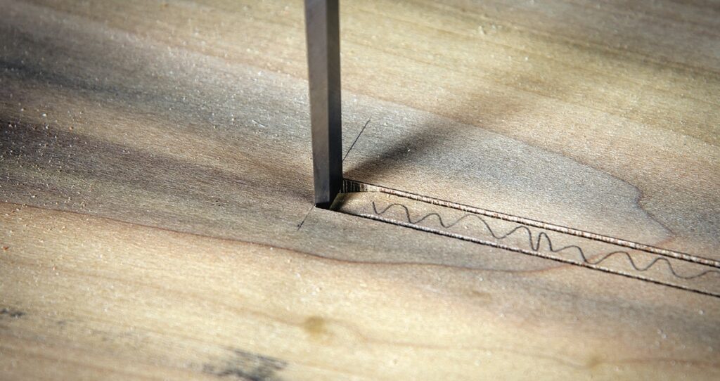 Saw cutting through wooden board