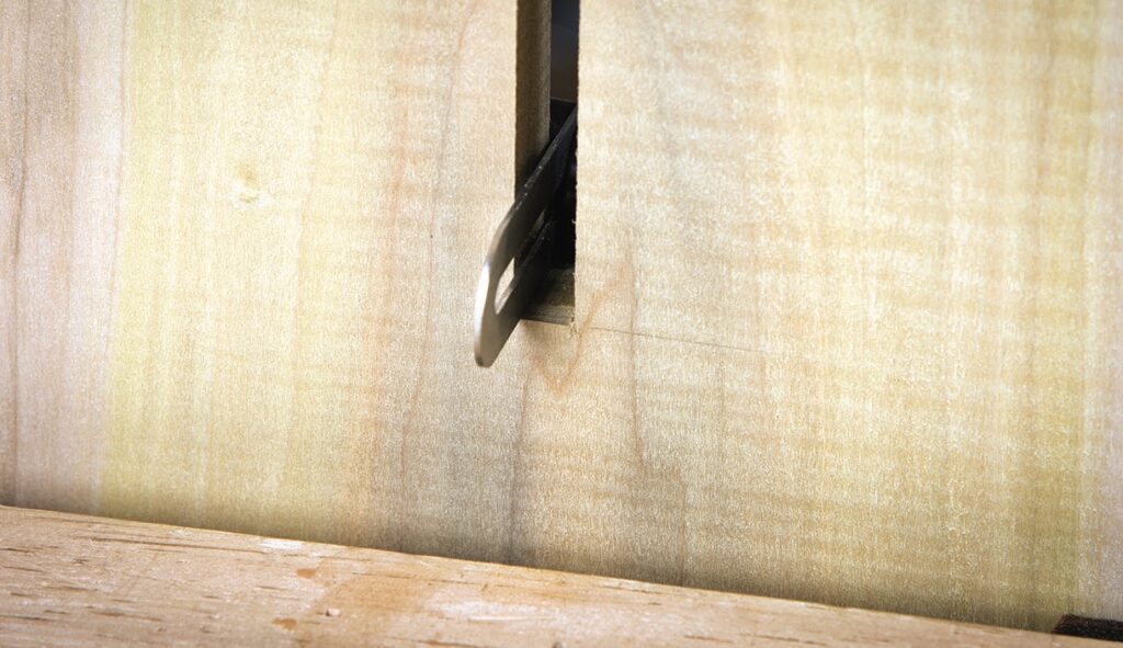 Saw blade cutting through wood board