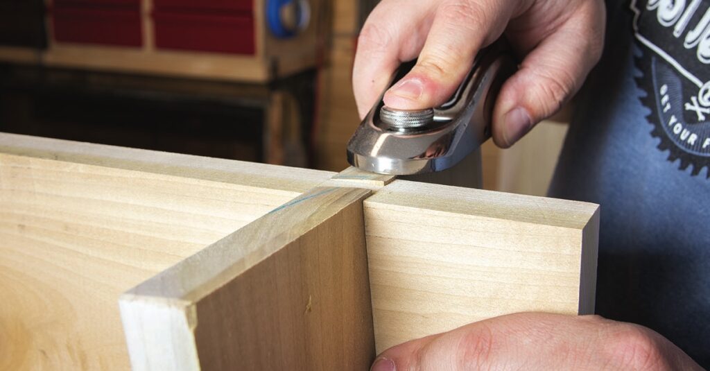 Cutting wood with hand plane tool.